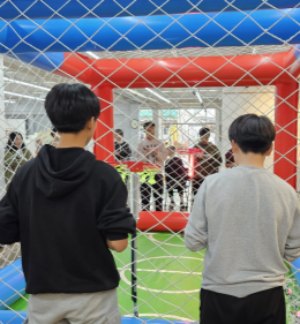 Students flying in a drone soccer arena