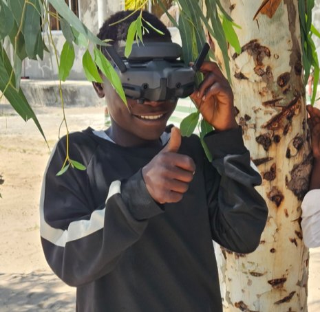 Pupil in Maputo giving a thumbs-up while wearing FPV goggles